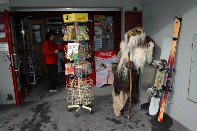 Ein Tschäggättä lauert an der Fasnacht in Lötschental vor einem Kiosk seiner  Beute auf.