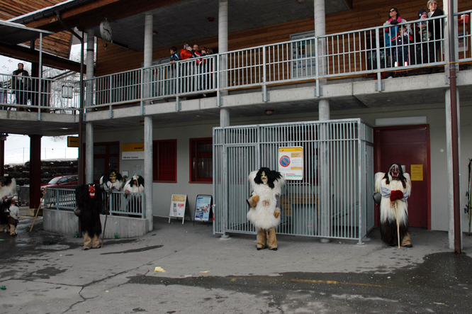 An der Fasnacht in Lötschental wird der Eingang der Post von fünf hungrigen Tschäggättä besetzt.